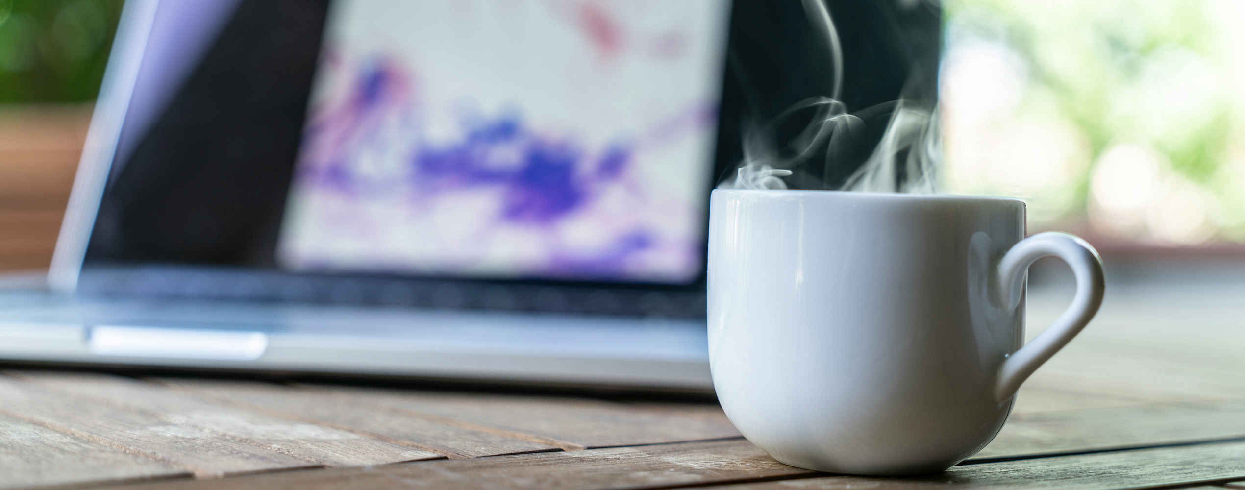 image of a table with a hot coffee and a laptop
